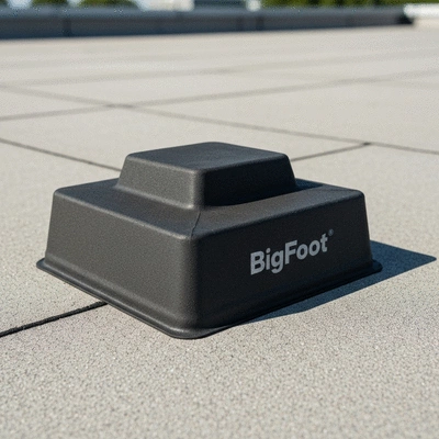 Gros plan sur une base de supportage BigFoot en caoutchouc recyclé, répartissant la charge sur une toiture